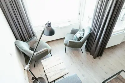 a living room with two chairs and a floor lamp at Zonnehoek 75 in Egmond aan Zee