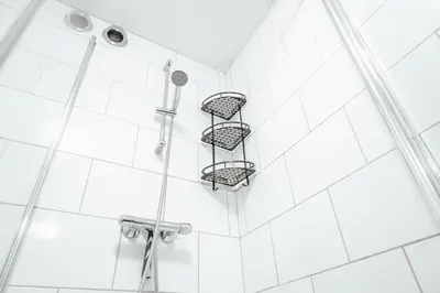 a shower with white tiles on the wall at Zonnehoek 75 in Egmond aan Zee
