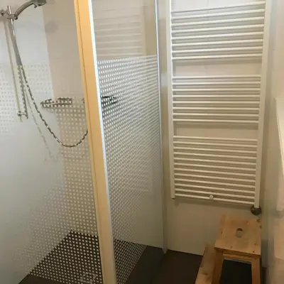 a shower with a glass door in a bathroom at Zonnehoek 77 in Egmond aan Zee