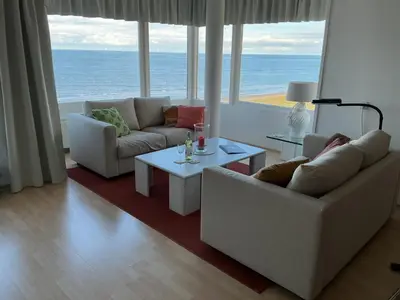 a living room with two couches and a view of the ocean at Zonnehoek 77 in Egmond aan Zee