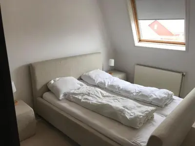 two pillows on a bed in a room with a window at The Lighthouse in Egmond aan Zee