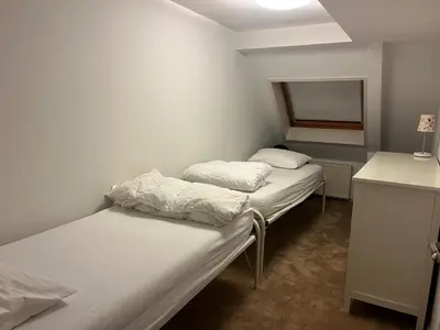 two beds in a small room with a window at The Lighthouse in Egmond aan Zee
