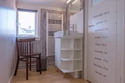 a room with a chair and a table and a shelf at Fay in Egmond aan Zee