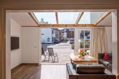 a living room with a couch and a table at Fay in Egmond aan Zee