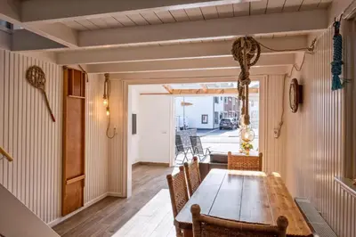 a dining room with a wooden table and chairs at Fay in Egmond aan Zee