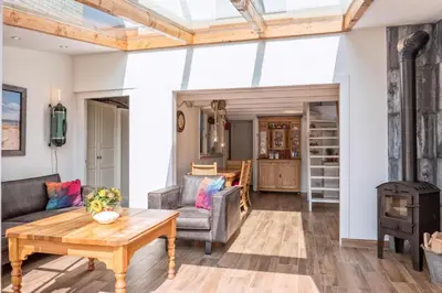 a living room with a fireplace and a wood stove at Fay in Egmond aan Zee