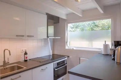 a kitchen with a sink and a window at Fay in Egmond aan Zee