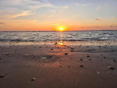a sunset on a beach with the ocean at Atlantis 14c in Egmond aan Zee