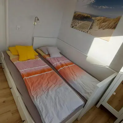 two twin beds in a room with a wall at Atlantis 14c in Egmond aan Zee