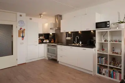 a kitchen with white cabinets and a stove top oven at Zonnehoek 63 in Egmond aan Zee