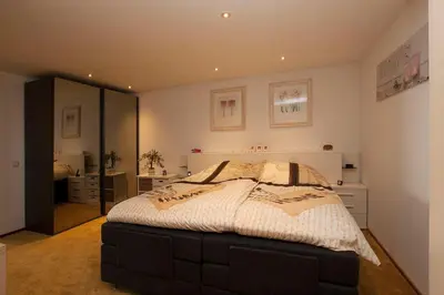 a bedroom with a bed and a large mirror at Zonnehoek 63 in Egmond aan Zee