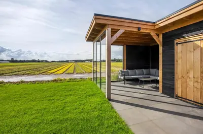 a house with a patio with a view of a field at Appartementen De Wilg - Adults only in Noordwijk aan Zee