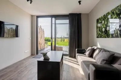 a living room with a couch and a table at Appartementen De Wilg - Adults only in Noordwijk aan Zee