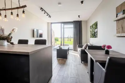 a kitchen and dining room with a table and chairs at Appartementen De Wilg - Adults only in Noordwijk aan Zee