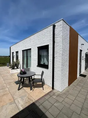 a patio with a table and a building at Tulip Lodges in Voorhout