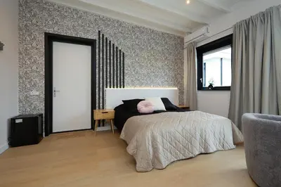 a bedroom with a bed and a window and a chair at Tulip Lodges in Voorhout