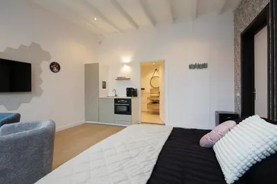 a bedroom with a bed and a living room at Tulip Lodges in Voorhout