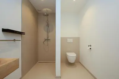 a bathroom with a toilet and a shower stall at Tulip Lodges in Voorhout