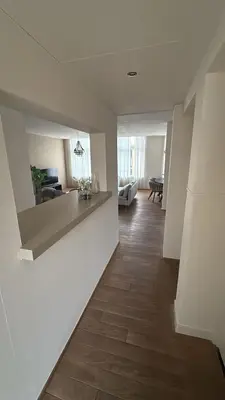 a living room with white walls and a wooden floor at Saya Loft in Amersfoort