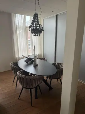 a dining room table with chairs and a chandelier at Saya Loft in Amersfoort