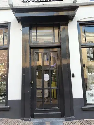 a black door on a white building with windows at Saya Loft in Amersfoort