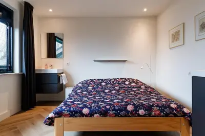 a bedroom with a bed with a floral bedspread at Easy Sleep Lelystad in Lelystad
