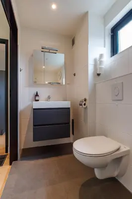 a bathroom with a white toilet and a sink at Easy Sleep Lelystad in Lelystad