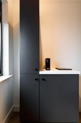 a black cabinet in a room with a desk at Easy Sleep Lelystad in Lelystad