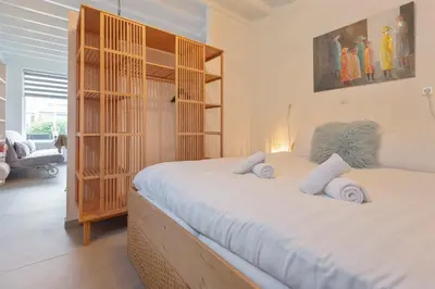 a bedroom with a large bed with white sheets at Cosea Beach House in Zandvoort