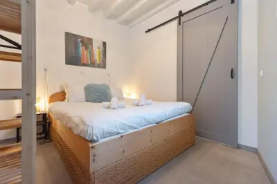 a bedroom with a bed and a sliding door at Cosea Beach House in Zandvoort