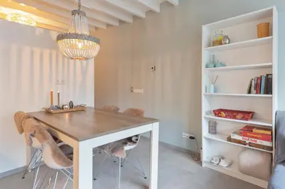 a dining room with a table and chairs and a chandelier at Cosea Beach House in Zandvoort