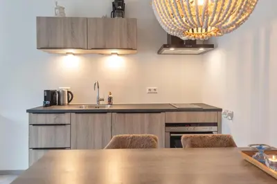 a kitchen with a table with chairs and a sink at Cosea Beach House in Zandvoort
