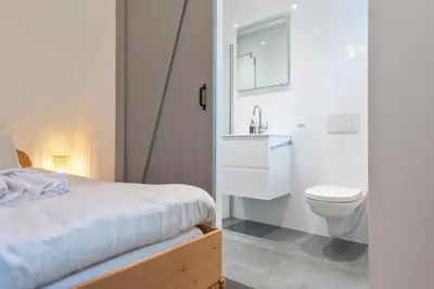 a white bathroom with a toilet and a sink at Cosea Beach House in Zandvoort