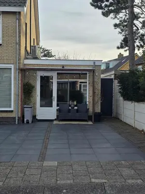 a patio with a couch in front of a house at Cosea Beach House in Zandvoort
