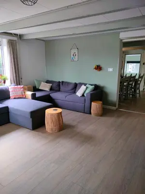a living room with a purple couch and two tables at Vroonenburch in Burgerbrug