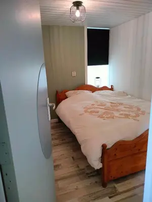 a bedroom with a large bed with a wooden floor at Vroonenburch in Burgerbrug