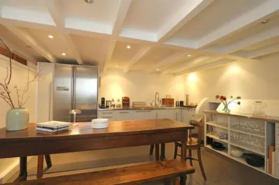 a kitchen with a wooden table and a refrigerator at Gwendolynn lovely holiday home in Bergen
