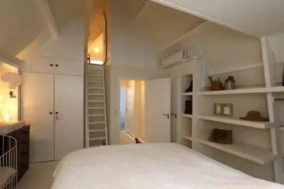 a bedroom with a white bed and shelves at Gwendolynn lovely holiday home in Bergen