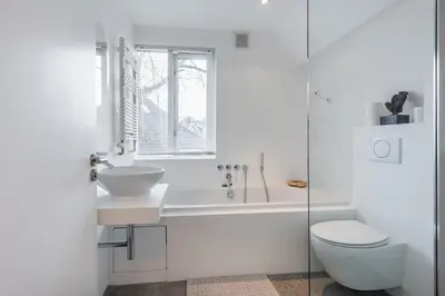 a white bathroom with a sink and a toilet at Gwendolynn lovely holiday home in Bergen