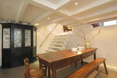 a dining room with a wooden table and stairs at Gwendolynn lovely holiday home in Bergen