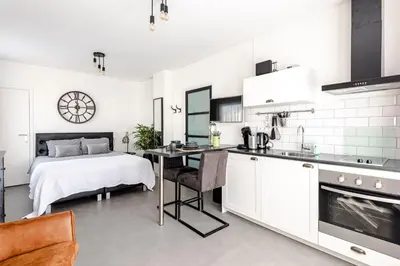 a kitchen and a bedroom with a bed and a table at Beach and Dunes Studio - Free Parking in Zandvoort