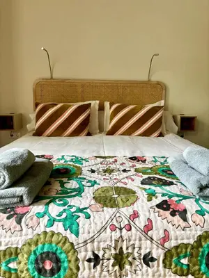 a bed with a colorful quilt on top of it at Logies Reederij de IJsel in Gouda