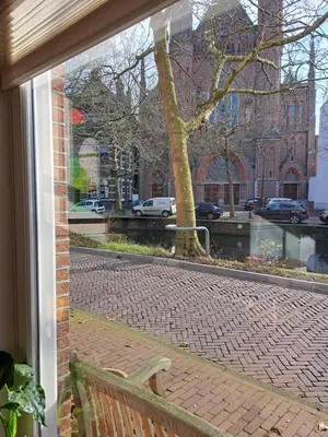 a window view of a brick street with a bench at Logies Reederij de IJsel in Gouda