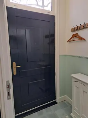 a black door in a bathroom with a window at Logies Reederij de IJsel in Gouda