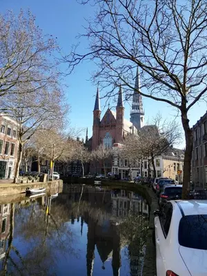 a view of a city with a river and a building at Logies Reederij de IJsel in Gouda
