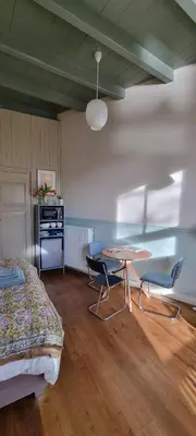 a bedroom with a bed and a table and chairs at Logies Reederij de IJsel in Gouda
