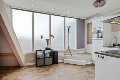 a kitchen with white walls and large windows at Apartment at the harbor in Monnickendam