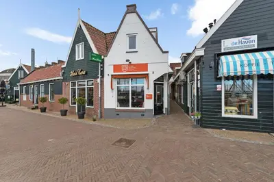 a row of shops on a street in a town at Apartment at the harbor in Monnickendam