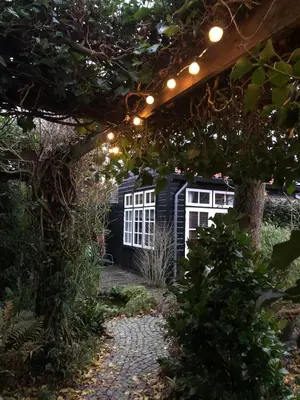 a garden with a pergola and a house at t Ateliertje Noort in Bergen
