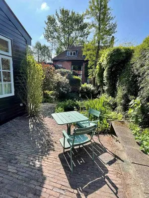 a picnic table and a bench in a garden at t Ateliertje Noort in Bergen